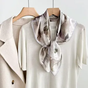 Detailed view of abstract printed silk square scarf styled elegantly on neutral knitwear.
