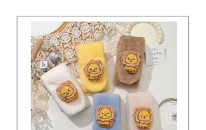 Détail de tour de cou croisé peluche pour enfants avec broderie lion et fausse fourrure douce.