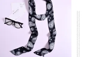 Vista dettagliata di un elegante foulard stretto in seta con stampa cachemire in bianco e nero.