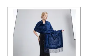 Vista dettagliata di uno lussuoso scialle in velluto blu jacquard con frange eleganti.