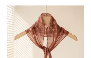 Close-up detail of the vintage brown floral paisley small scarf, elegant neckwear decoration.