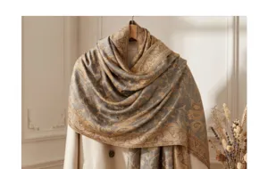 Detailed view of vintage paisley jacquard winter scarf shawl, elegant grey and gold tone drape.