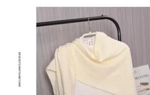 Scialle in lana lavorata a maglia gialla, dettaglio collo triangolare caldo invernale.