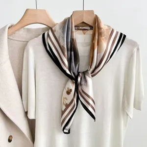 Close up view of the elegant silk scarf with abstract print and delicate striped border.