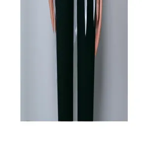 Image de détail d'un pantalon sombre et moulant avec un tissu lisse sur fond gris neutre.