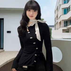 Detailed view of the elegant polka dot skinny silk scarf worn by a model outdoors.