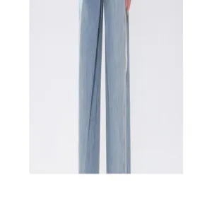 Gros plan détaillé du pantalon large bleu, coupe ample décontractée et style épuré.