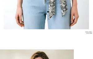 Vista dettagliata di un foulard stretto bianco e nero elegante indossato come cintura sui jeans.