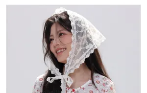 Détail en gros plan d'un foulard triangulaire en dentelle florale blanche avec lien.