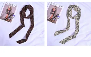 Vista dettagliata di eleganti sciarpe twilly sottili con stampa vintage, ideali per collo o borse.