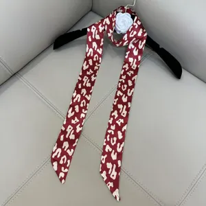 Elegant narrow long silk scarf with chic abstract print, versatile accessory for women.