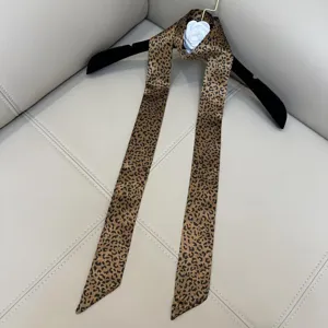 Leopard print skinny scarf detail, smooth satin fabric, elegant neck accessory for women.
