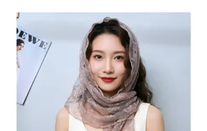 Vue détaillée d'un foulard triangulaire en dentelle française avec de délicates broderies.