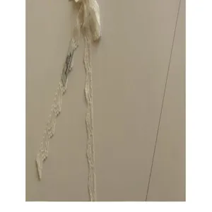 Vue détaillée du ruban et de la sangle en dentelle florale blanche, montrant une texture délicate.