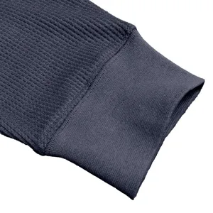 Detailed view of men's long sleeve waffle knit shirt cuff in dark grey, classic casual basic style.