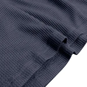Close-up detail of dark grey ribbed fabric texture showing fine stitching and stretch knit quality.