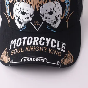 Détail de casquette de baseball en mesh noir avec broderie tête de mort et lettrage moto.