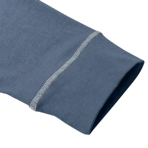 Men's long-sleeve henley shirt cuff detail close-up, blue-grey fabric with contrast stitching.