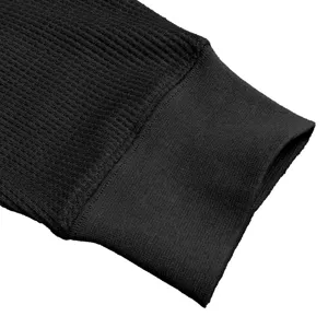 Detail shot of black waffle knit long sleeve shirt cuff, showing premium texture and ribbed hem.