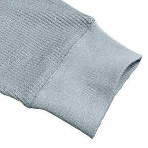 Detail of men's grey waffle knit long sleeve shirt cuff texture close up view product display