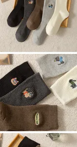 Close-up detail of ribbed cotton socks with cute cat embroidery and soft knit texture.