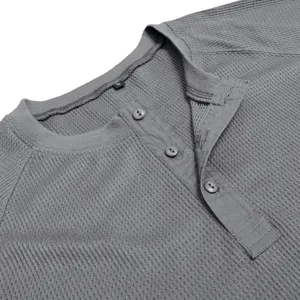 Close-up detail of men's grey waffle-knit long-sleeve Henley shirt collar and three buttons.