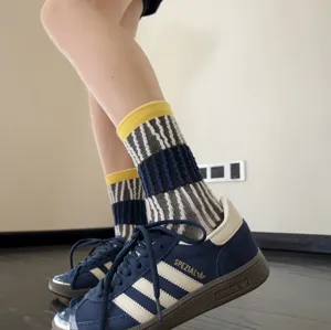Chaussettes mi-hautes tendance pour femmes, design rayé élégant, chaussettes décontractées streetwear.