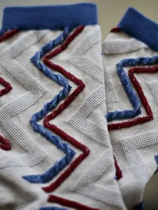 Gros plan élégant de chaussettes en tricot avec des rayures géométriques texturées.