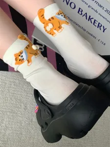 Cute 3D cat pompon mid-tube socks detail view, funny cartoon kitty white socks close up.