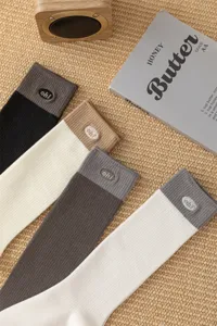 Vista dettagliata di calze a costine bicolore con grazioso design a lettere ricamate.