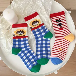 Close-up detail of cute cat patterned cotton socks with colorful vintage grid and stripe design.