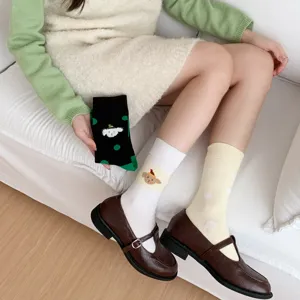Calzini verdi a pois da donna con simpatico disegno di cartoni animati, design asimmetrico.