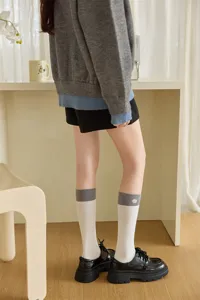 Vista dettagliata di eleganti calze a metà polpaccio ricamate bicolore da donna in primavera.