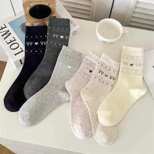 Cute bow patterned knit mid-calf socks detail shot showing soft cotton texture and retro style.