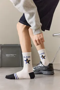 Gedetailleerde opname van trendy heren halfhoog sportkousen met ster- en letterprint.