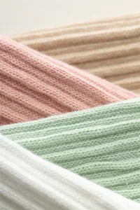 Nahaufnahme der Stricktextur von Damensocken mit sanften Pastellfarben und geripptem Design.