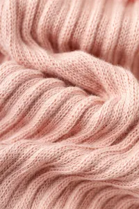 Nahaufnahme des weichen rosa gerippten Strickstoffs mit feiner Textur und gemütlichem Material.