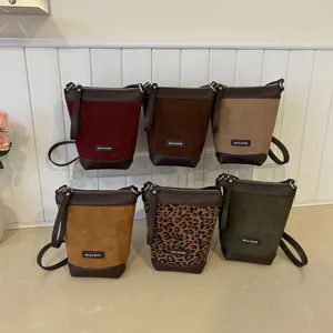 Detailed view of fashionable mini shoulder bags featuring multiple color options and suede finish.