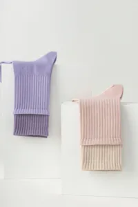 Close-up detail of soft ribbed women yoga socks displayed on white blocks, clean minimalist style.