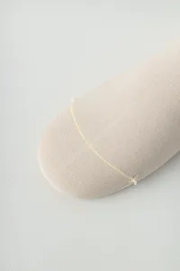 Close-up detail of seamless yoga socks toe part, soft beige knit fabric, comfortable fit.