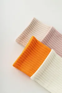 Gros plan de chaussettes de yoga côtelées aux coloris vifs, texture tricotée douce.