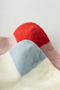 Gros plan de chaussettes de yoga colorées avec des points en silicone et texture tricotée.