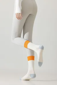 Vue de détail de chaussettes de yoga et pilates antidérapantes pour femmes à revers orange.
