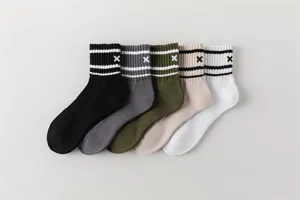 Close-up detail of striped athletic crew socks with embroidered accent, breathable cotton blend.