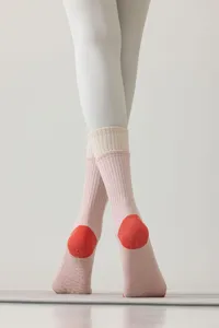 Gros plan de chaussettes de yoga pour femmes avec picots en silicone et talons contrastés.