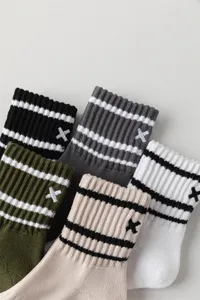 Detail shot of men's mid-calf striped cotton socks with embroidered X logo and cozy loop sole.