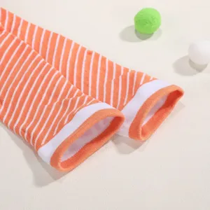Detaillierte Nahaufnahme von kreativ gestreiften Lachs-Socken in Orange und Weiß