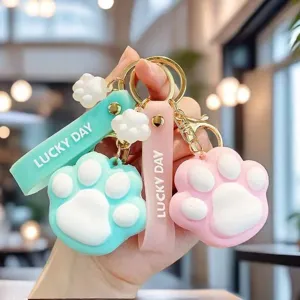 Close-up of cute macaron cat paw keychain with Lucky Day silicone strap detail.