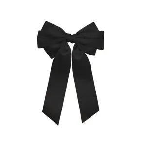 Gros plan détaillé de la barrette à cheveux nœud en satin noir à trois couches.