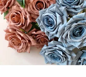 Close-up of realistic artificial roses in dusty pink and muted blue for home decor.